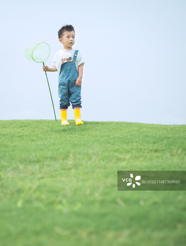 男孩站在草坪上图片素材