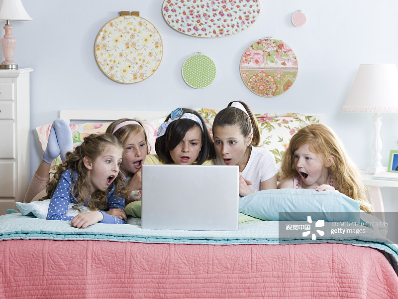 五個女孩在床上用筆記本電腦圖片素材