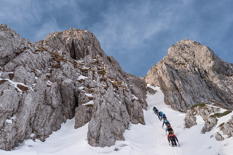 人們攀登雪山的低角度視圖圖片素材