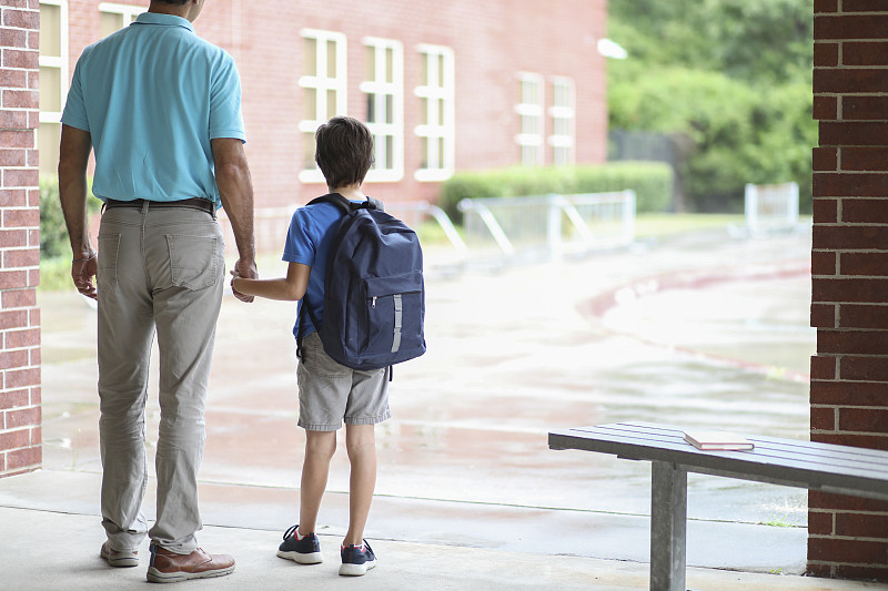小學男孩和爸爸一起去上課。圖片素材