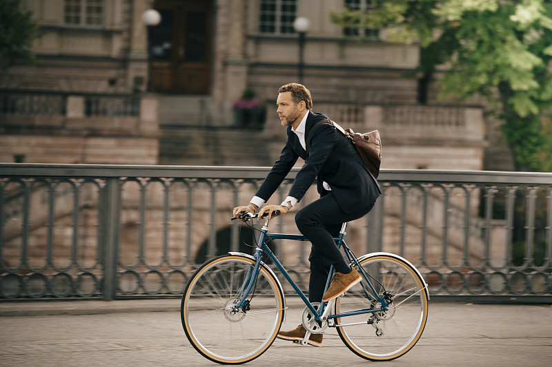 在城市街道上騎自行車的商人圖片素材