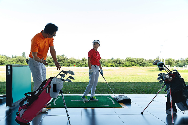 練習場上教練指導兒童打高爾夫圖片素材