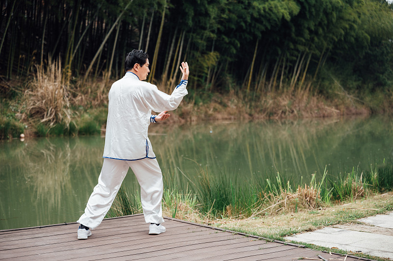 亞洲老年男性在湖邊打太極拳圖片素材
