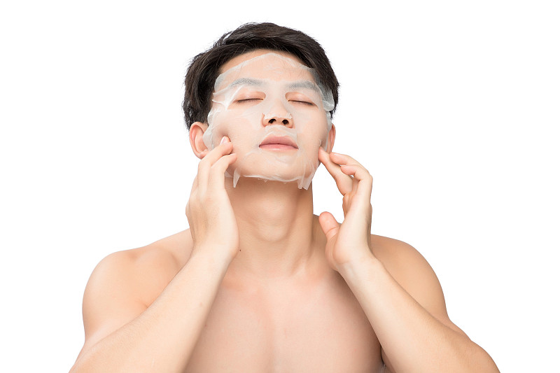 白色背景里的敷著面膜的亞洲男士面部特寫，化妝護膚整容圖片素材