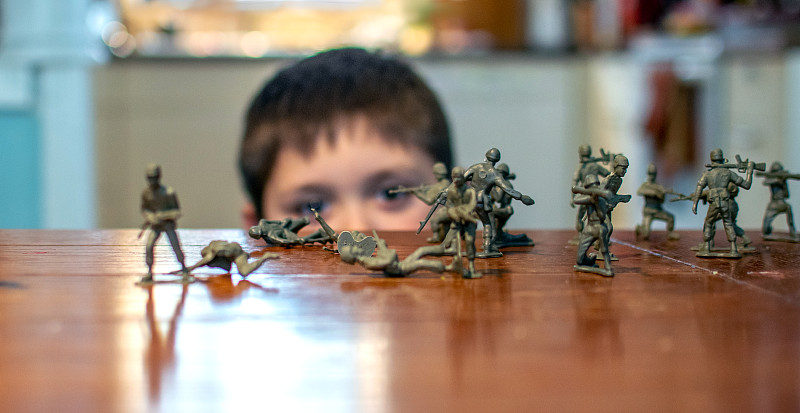 一個男孩和桌上的玩具士兵的肖像圖片素材