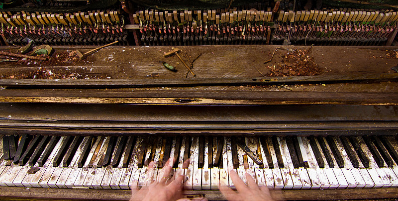 幽靈般的手彈奏著一架久經風霜的破舊鋼琴圖片素材
