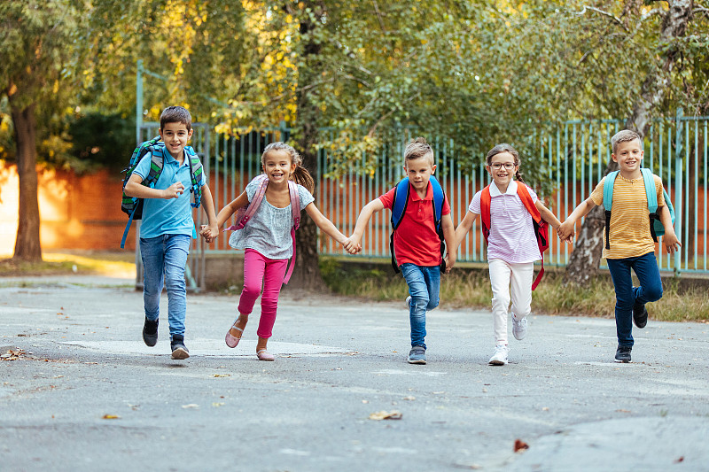 快樂的孩子們手拉手，下課后快樂的奔跑圖片素材