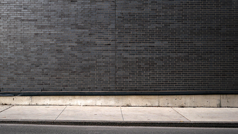 空曠干凈的灰色磚墻，混凝土人行道和瀝青街道在蒙特利爾，Qc，加拿大攝影圖片