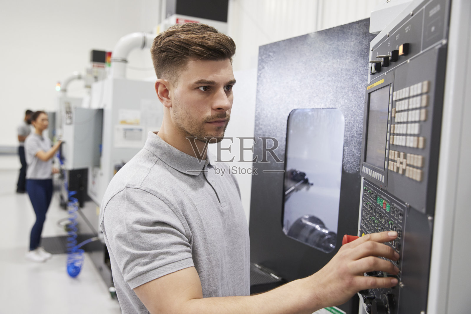在工厂操作数控机械的男工程师照片摄影图片