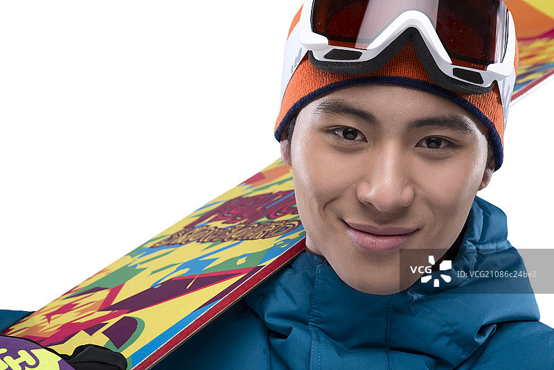 Young man with ski on shoulder smiling图片素材