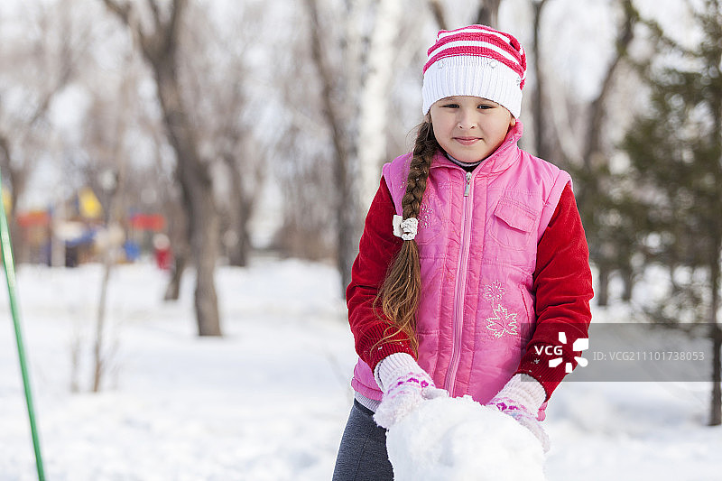 可爱的女孩的学校年龄有乐趣在冬季公园。冬天的活动图片素材