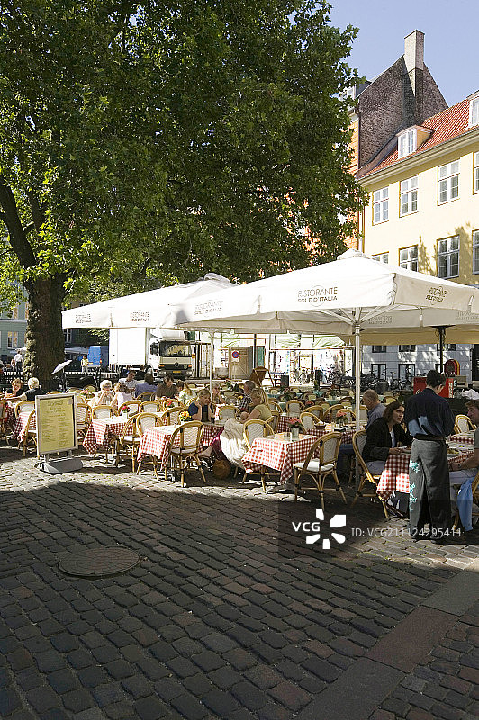 人们坐在丹麦哥本哈根Grabrodretorv广场的Sole d'Italia餐厅图片素材