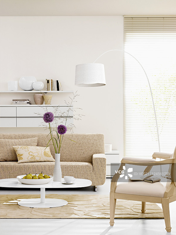 奶油色沙发和扶手椅，配有白色弧光灯，桌上放着梨子图片素材