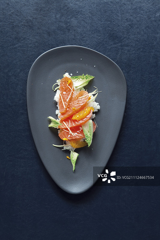 腌鲑鱼生鱼片配米饭和橙菊苣在椭圆形盘子里图片素材