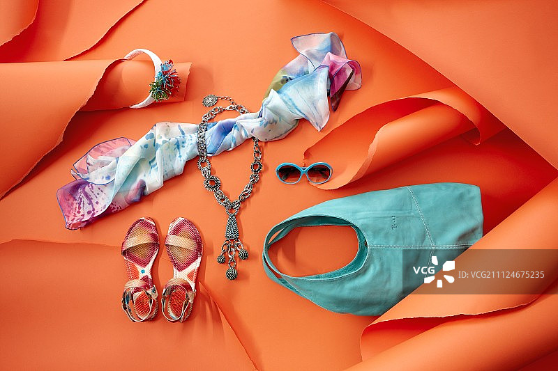 鞋，布，包和太阳镜在南海风格在橙色的背景图片素材