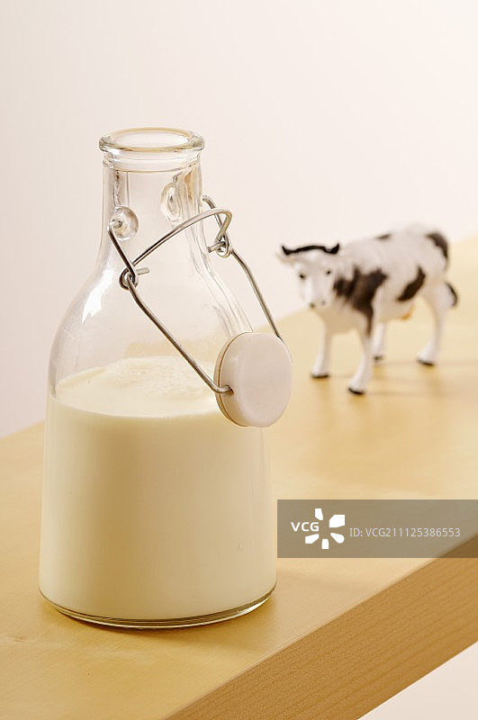 一瓶牛奶和一头塑料奶牛图片素材