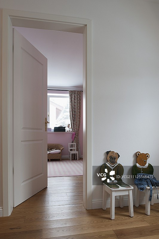 儿童椅子与雕刻，油漆，动物靠背旁边打开的门通往孩子的卧室图片素材