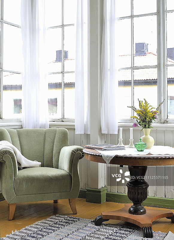 复古风格的窗边，天鹅绒扶手椅和鲜花摆在Biedermeier圆桌上图片素材