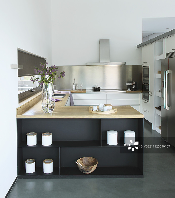 优雅的配备厨房，u形柜台装饰着锅和橄榄木碗，纯粹的风格图片素材