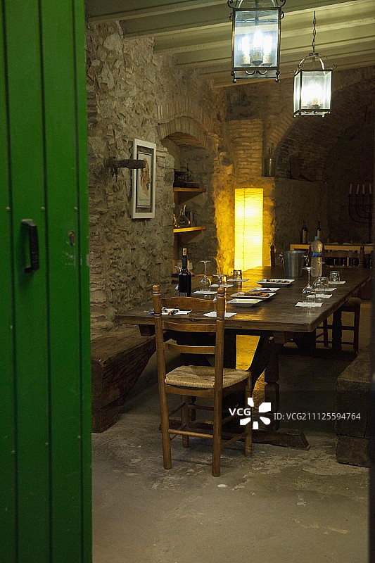 餐厅里深色的木桌，质朴的石墙，角落里的标准灯和壁龛里的木架图片素材