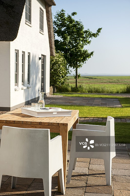 白色，塑料，现代户外椅子和木制桌子在夏季阳台度假家图片素材
