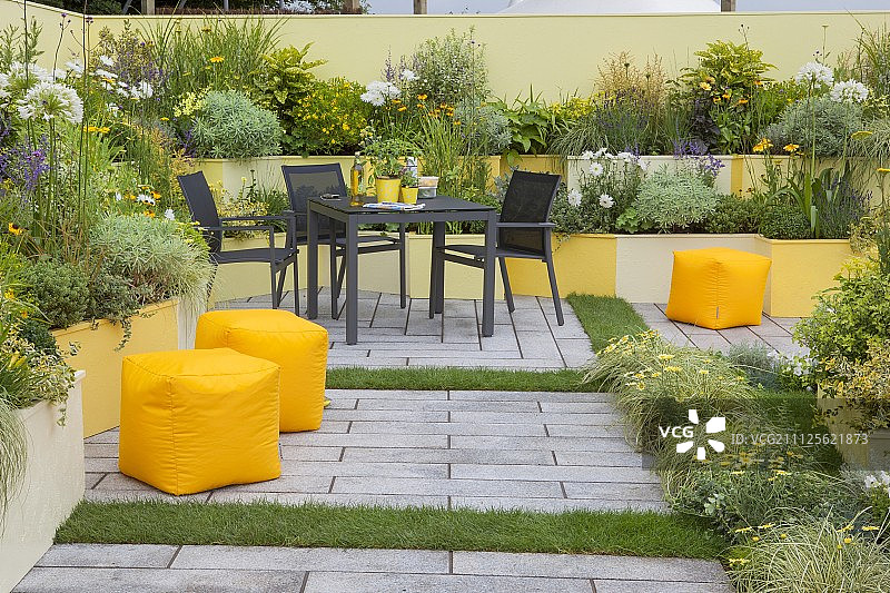 庭院花园的座位区，有各种黄色的梯田花坛图片素材