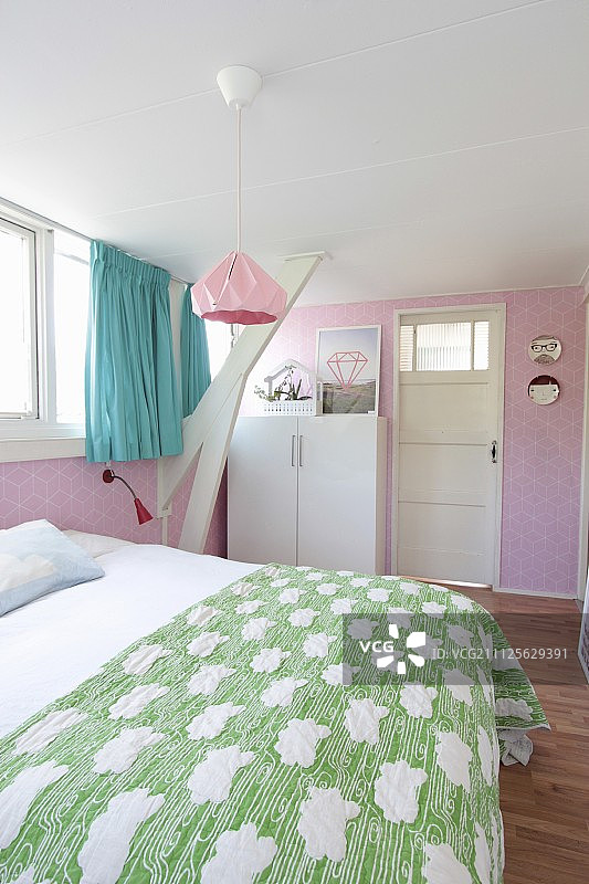 阁楼卧室里有粉红色的墙纸和绿松石色的窗帘图片素材