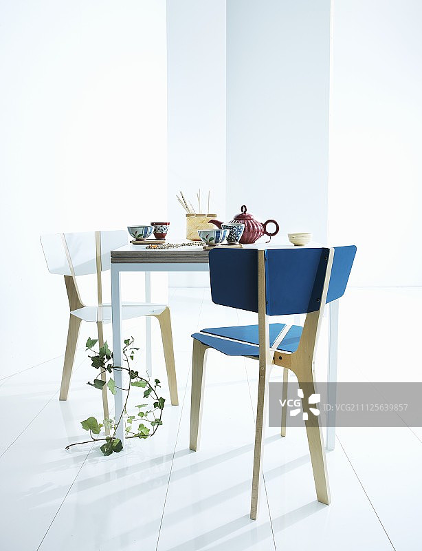 方桌旁的一对椅子，上面摆满了茶具和常春藤图片素材
