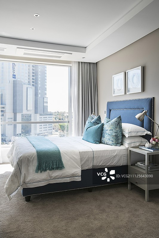 床与软垫蓝色框架和米色地毯在优雅的卧室图片素材