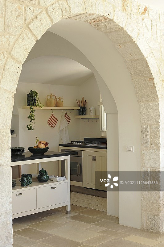 透过传统的拱形门道，可以看到现代乡村别墅的厨房图片素材