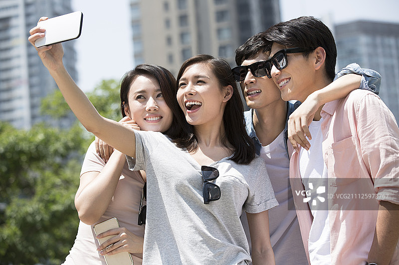 四个年轻人用手机自拍图片素材