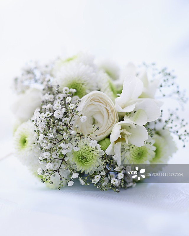 一个白色的婚礼花束，有婴儿的气息，玫瑰和非洲菊图片素材