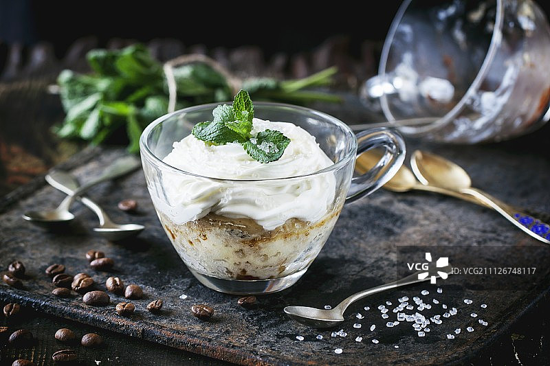 海绵蛋糕与奶油，咖啡和新鲜薄荷在一个玻璃杯图片素材