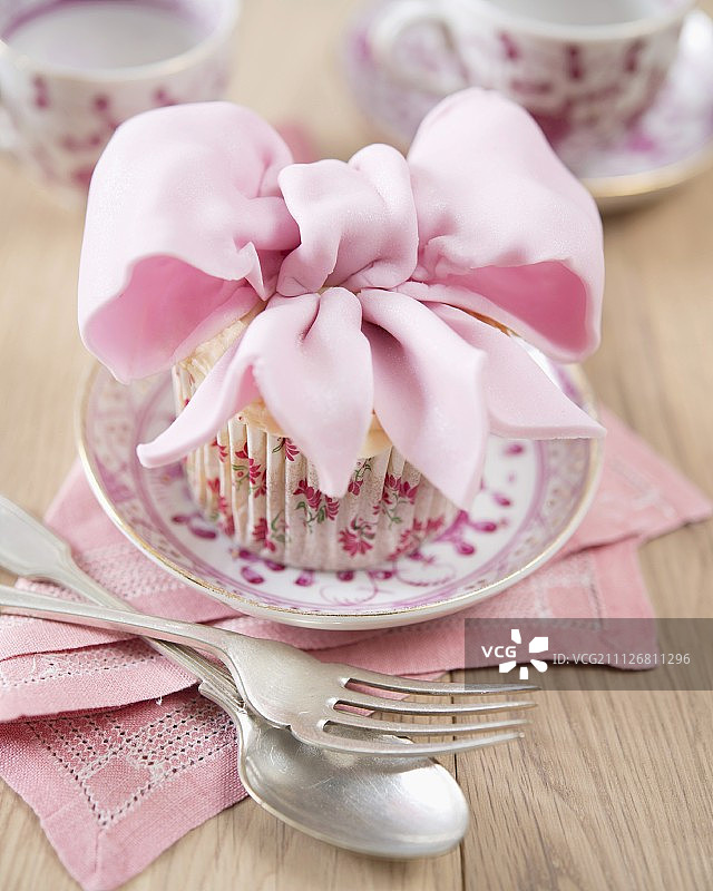一个装饰着方旦糖蝴蝶结的纸杯蛋糕图片素材