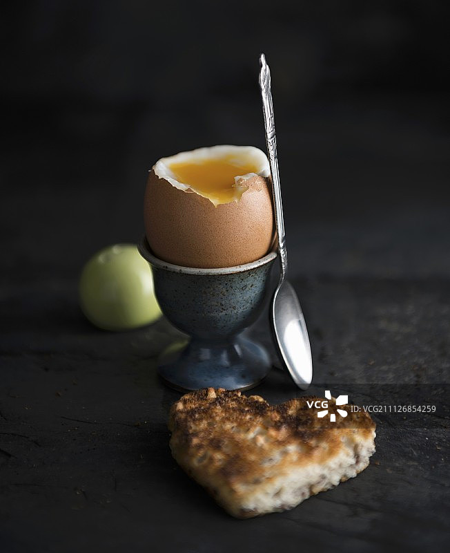 一个半熟的鸡蛋和一片心形的吐司图片素材