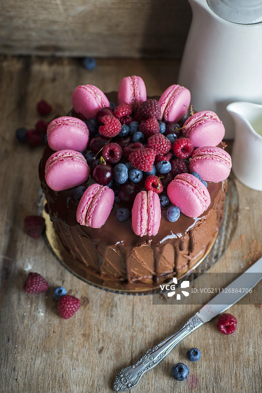用浆果和马卡龙装饰的巧克力蛋糕图片素材