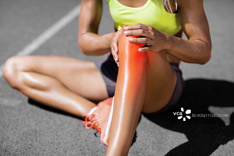 在阳光明媚的日子里，女运动员在赛道上忍受关节疼痛图片素材