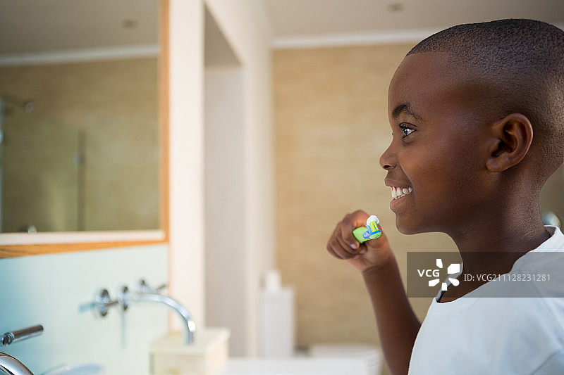 在家庭浴室微笑的男孩与牙刷的侧视图图片素材