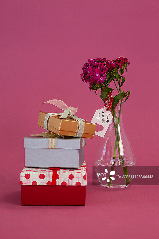 粉红色背景上的礼品盒和花瓶图片素材