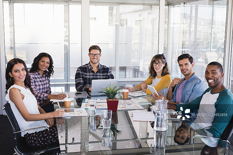 创意商业团队围绕着玻璃桌子工作的肖像图片素材
