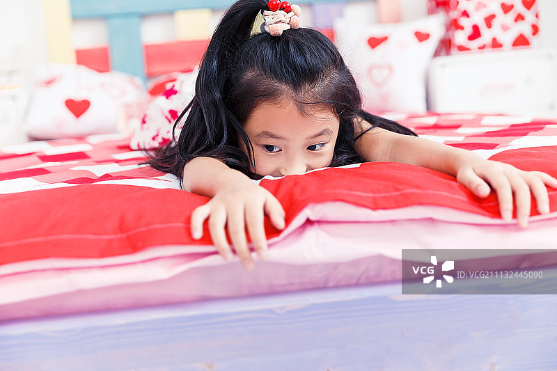 可爱的小女孩在床上玩耍图片素材