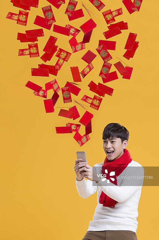 快乐的年轻男子用手机抢新年红包图片素材