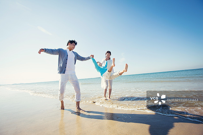 快乐的父母和儿子在海上图片素材