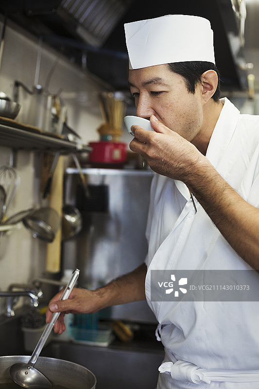 在日本寿司餐厅厨房工作的厨师，品尝食物。图片素材