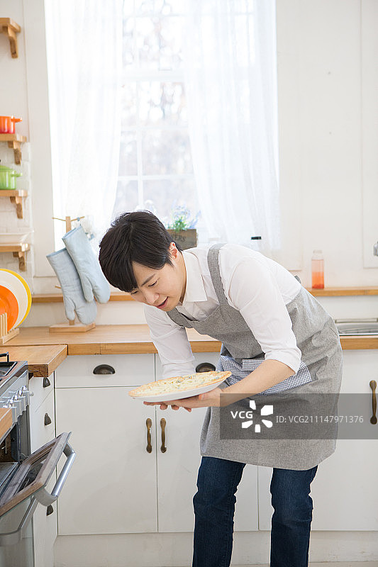 韩国人，男人，厨房，烹饪(食物状态)，食物准备(移动活动)，烤箱烘焙(烹饪)图片素材