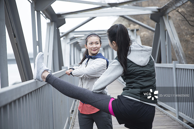 两个青年女子在跨海大桥上做户外健身运动图片素材