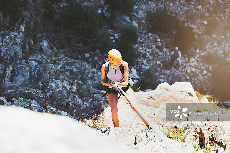 女性攀岩者正在攀爬岩石图片素材