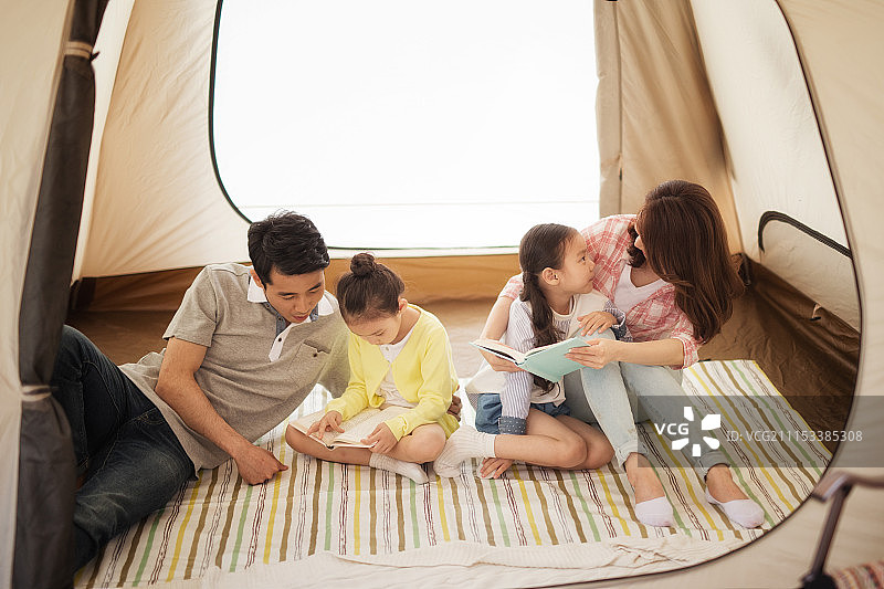 家庭在帐篷里一起看书图片素材