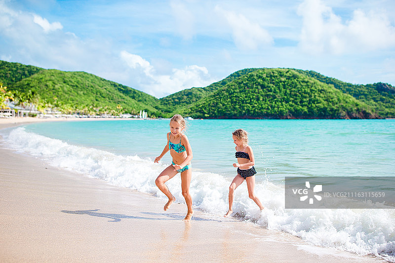 暑假期间，孩子们在热带海滩玩得很开心图片素材