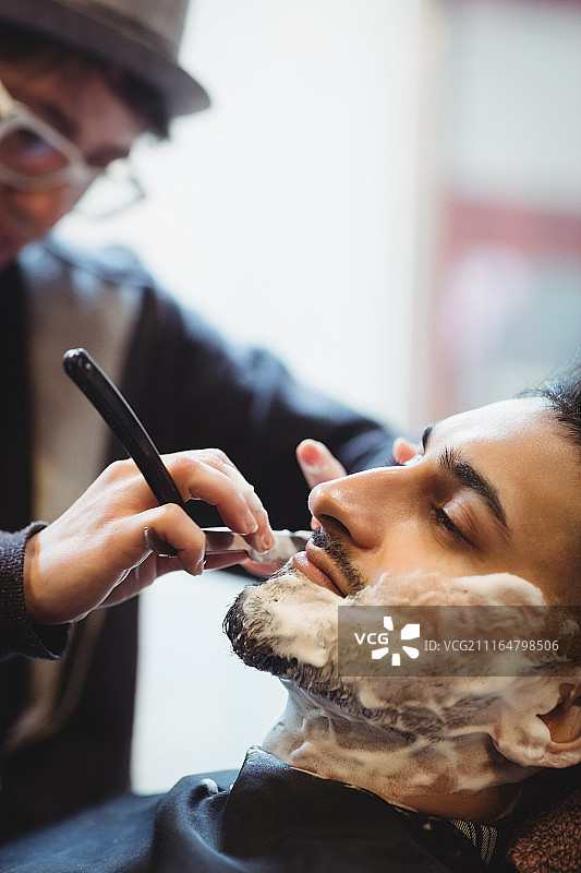 用剃刀刮胡子的男人图片素材
